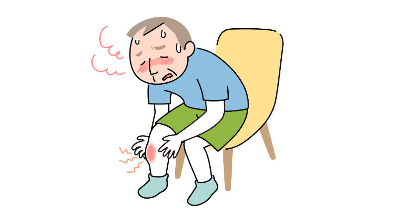 椅子に座り、すねを見ている小太りの60代男性。片方のすねが赤く腫れ上がっている。男性も発熱していて顔が赤い。
