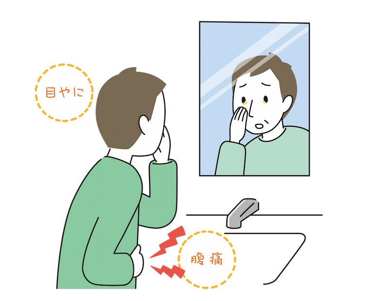 鏡の前で目やにを確認している男性