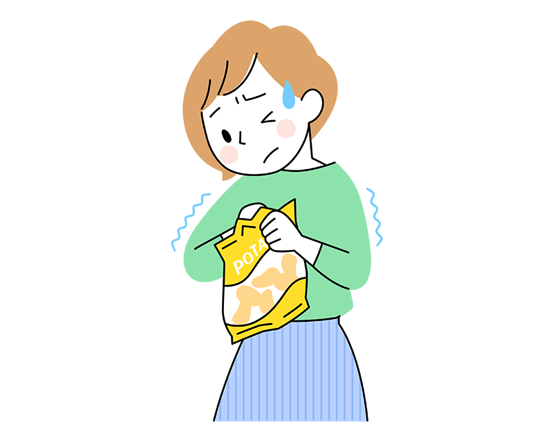 ポテトチップの袋を開けようとして苦労している40代女性
