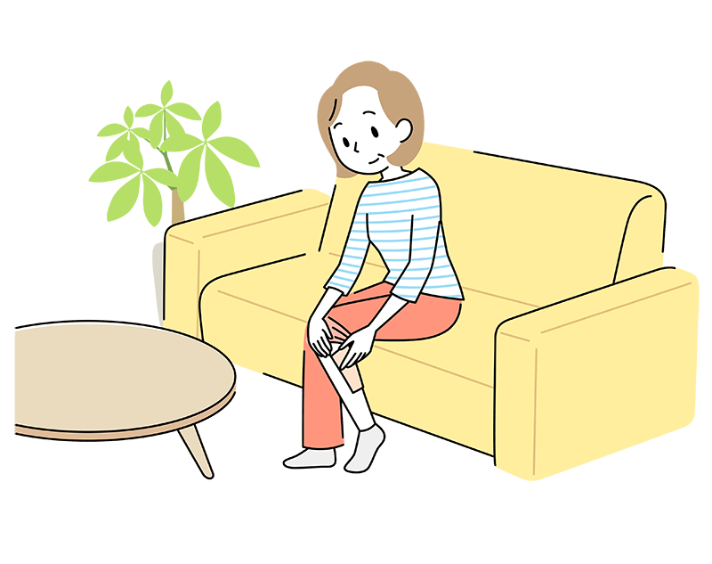 ソファーに座り、ふくらはぎに湿布を貼っている50代女性