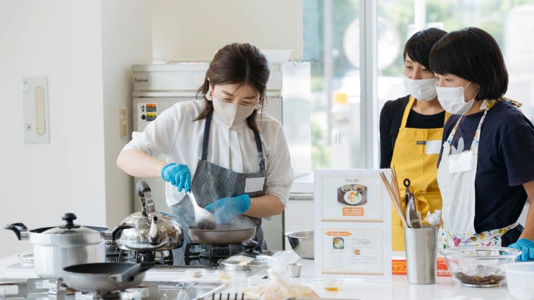 料理教室で作業をする３名の女性