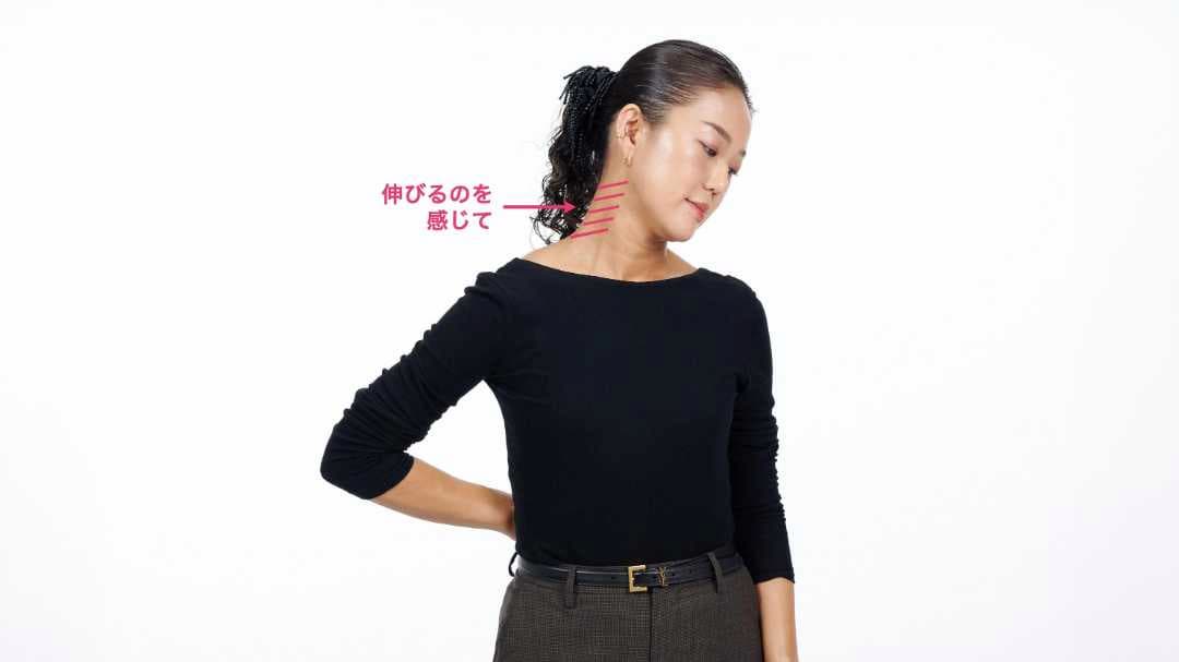 手の甲を腰に当て、頭を逆側に傾けて首のストレッチをしている写真