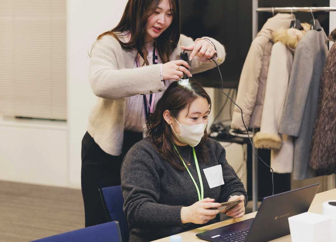 マイクロスコープを使い、自分の頭皮の状態をチェックする参加者